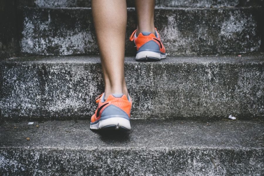 person-in-running-shoes-going-up-stairs